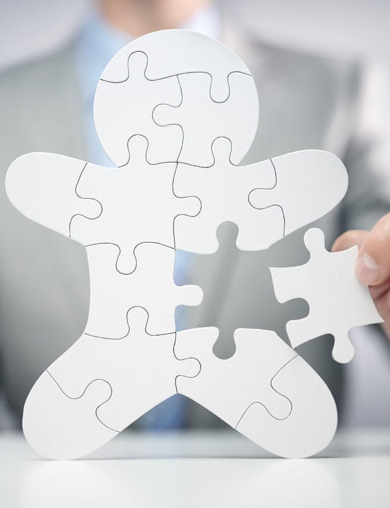 Geschäftsmann hält letzte Puzzleteil, symbolisiert Strategie oder Teamwork im Geschäft.