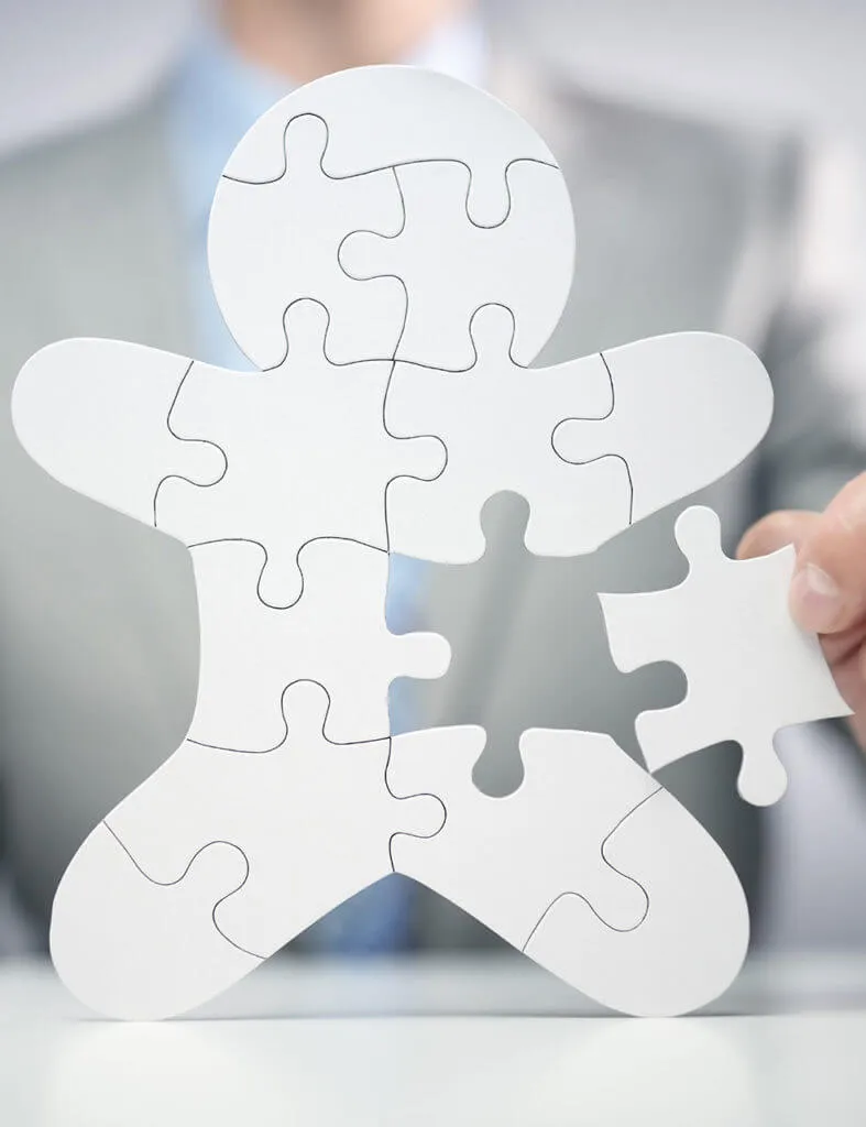 Geschäftsmann hält letzte Puzzleteil, symbolisiert Strategie oder Teamwork im Geschäft.