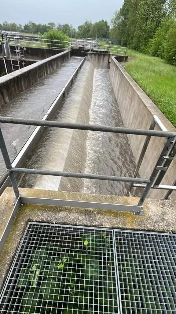 Abwasserbehandlungsanlage mit Wasserkanälen in grüner Umgebung.